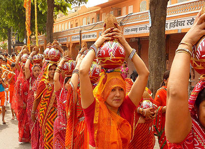 Teej Festival in Rajasthan, featuring women in vibrant attire, swings, and dances to honor Goddess Parvati and celebrate the monsoon.